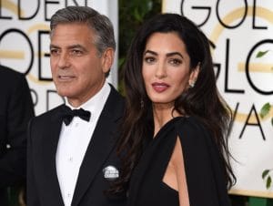 Actor George Clooney (L), wearing a "Je suis Charlie" button, and Amal Clooney arrive on the red carpet for the 72nd annual Golden Globe Awards, January 11, 2015 at the Beverly Hilton Hotel in Beverly Hills, California. AFP PHOTO / MARK RALSTON (Photo credit should read MARK RALSTON/AFP/Getty Images)
