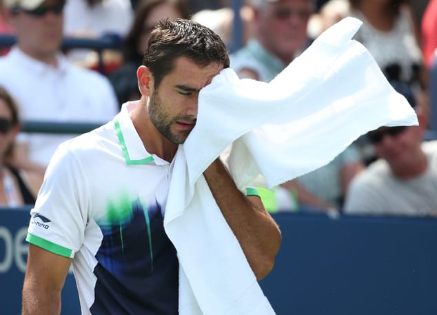 Marin Cilic, of Croatia, wipes sweat from his face between points against Kevin Anderson, of South Africa, of the 2014 U.S. Open tennis tournament, Sunday, Aug. 31, 2014, in New York. (AP Photo/John Minchillo)